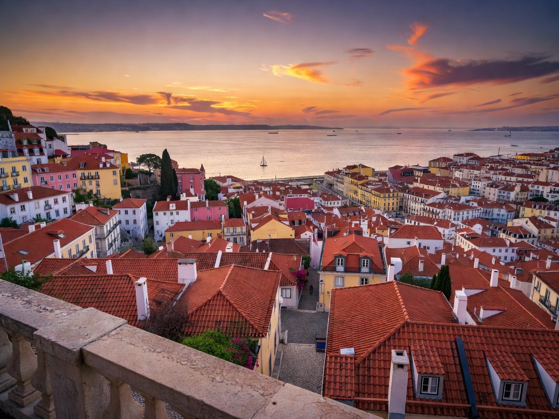 View from a Lisbon miradouro at dusk over terracotta rooftops towards the Tagus river